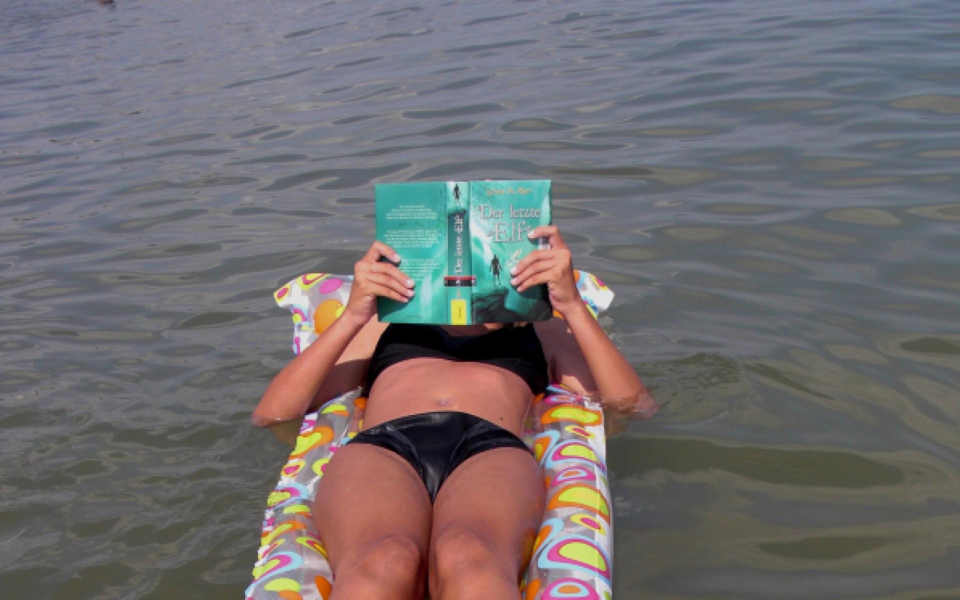 Lesen auf der Luftmatratze im Meer