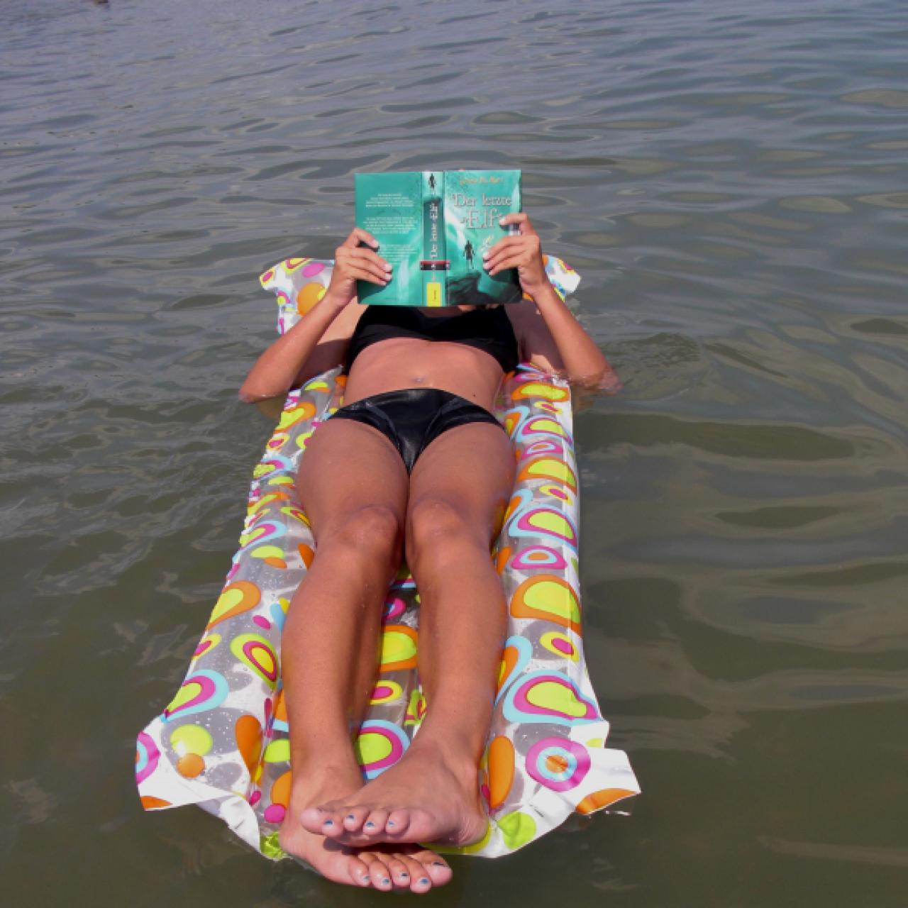 Lesen auf der Luftmatratze im Meer
